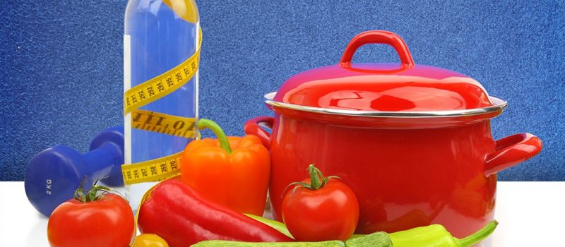 Diet concept with colorful vegetables and a red cooking pot